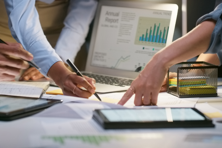 Team reviewing procurement data and analytics on documents and digital devices to enhance supplier visibility and improve sourcing decisions.