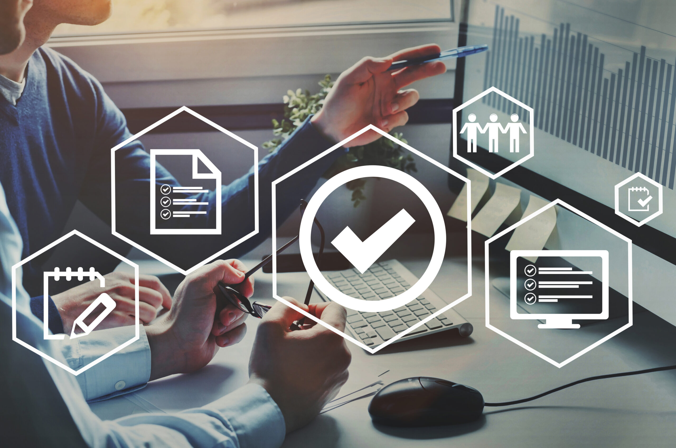 Team reviewing digital documents and analytics on a computer screen, with overlay icons representing checklists and successful submissions.