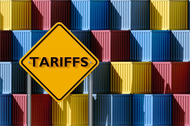Tariffs warning sign over shipping containers, representing how Canadian suppliers can navigate U.S. tariff impacts and market shifts.