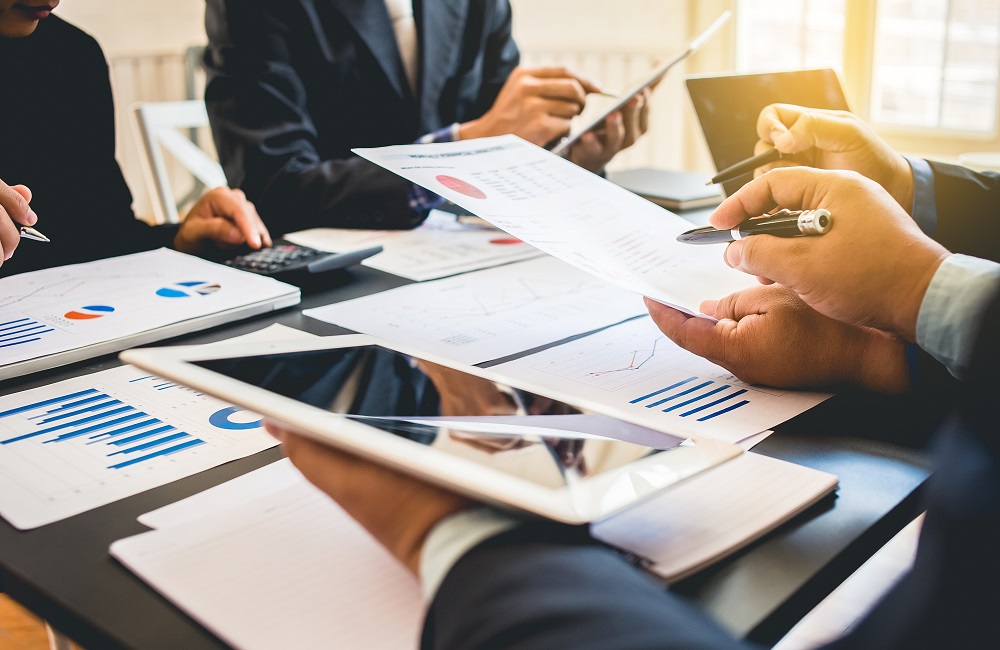 Business team reviewing charts, reports, and digital data together, representing strategic procurement optimization and cost-saving initiatives.